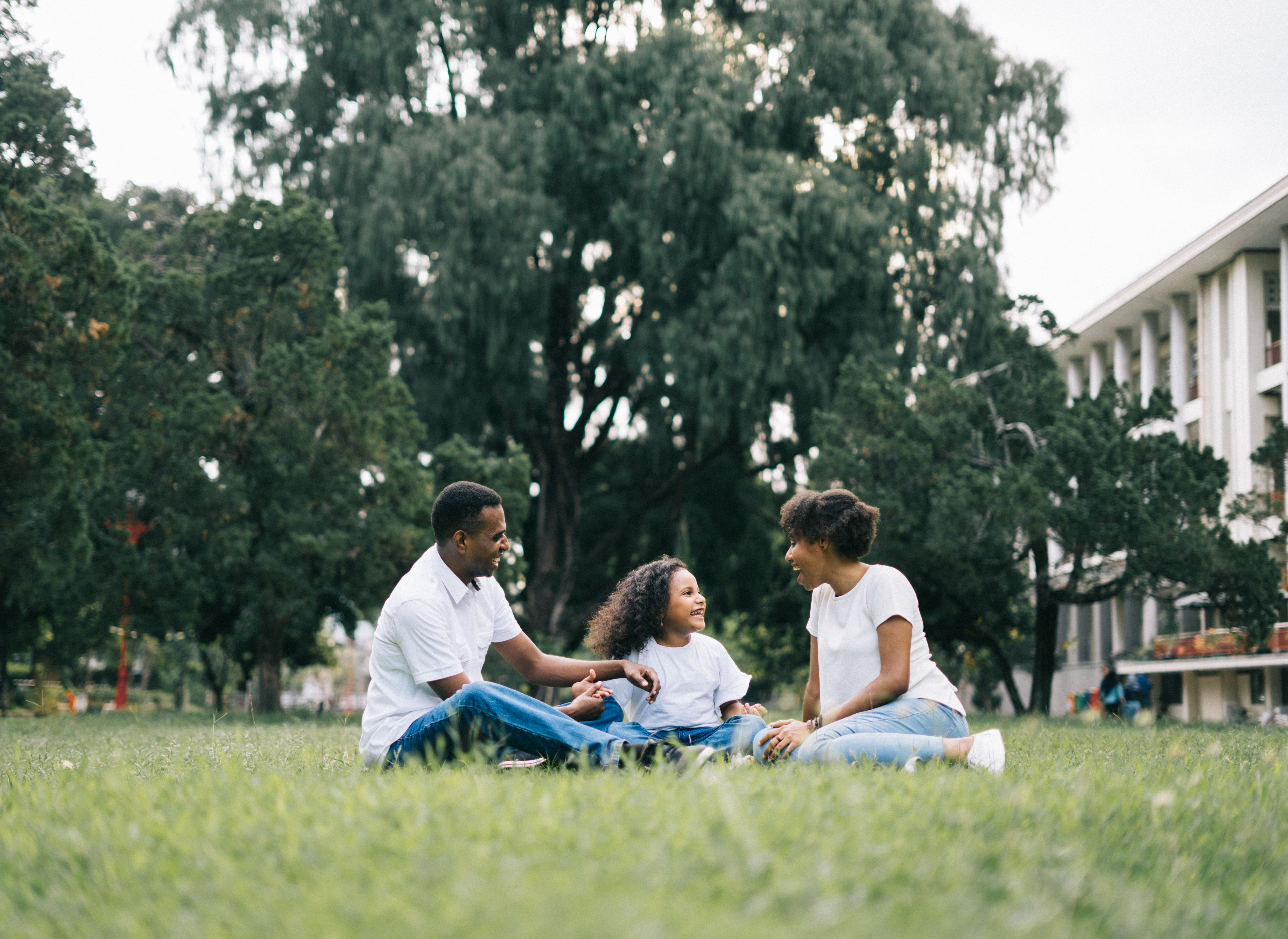 Canva - Family Sitting on Grass Near Building